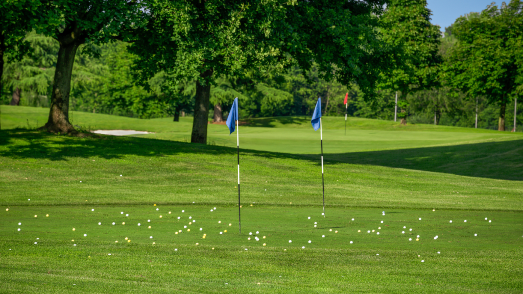 Golfer repeatedly hitting golf balls from the same spot on a driving range, illustrating repetitive practice habits in golf.