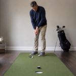 Golfer practicing at-home putting drills on an indoor putting mat to build trust and feel.