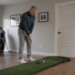 Golfer practicing a putting stroke at home to build rhythm, trust, and distance control.