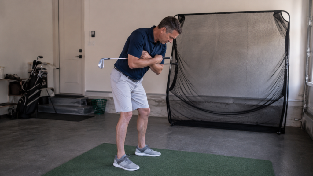Golfer using at-home wedge training to rehearse a movement pattern without overthinking on the course.