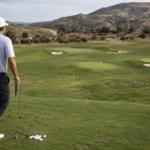 Experienced golfer at a grass range choosing between several course-like wedge targets with varied lies and landing areas.