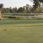 Experienced golfer practicing long putts on a green with a visible safety zone around the hole, calm balanced stroke.